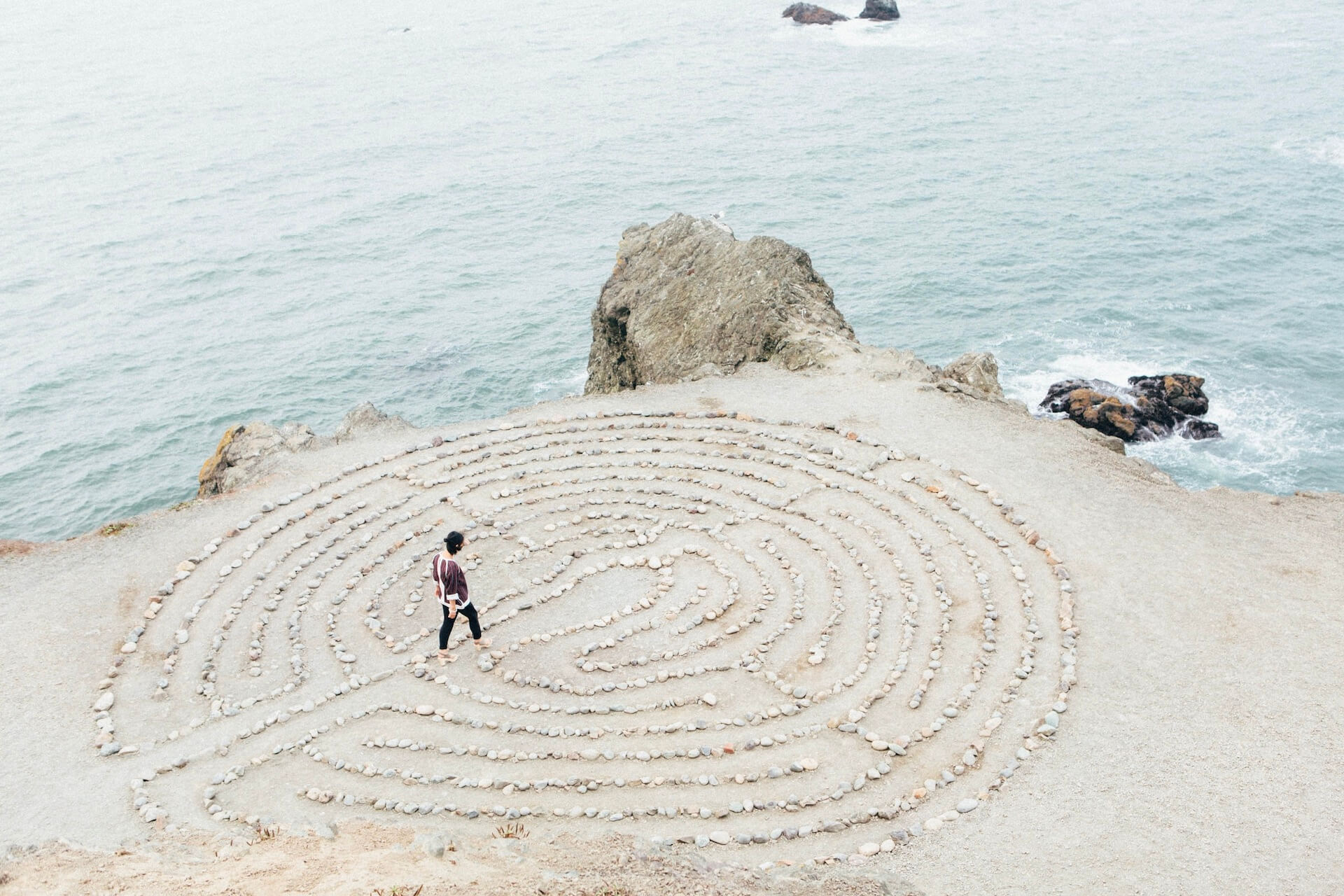 Frau läuft über ein Steinlabyrinth und erkennt neue Wege